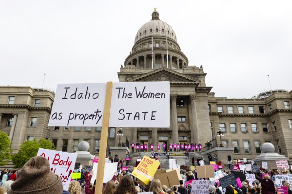 FILE - An attendee at Planned Parenthood's Bans Off Our Bodies rally for abortion rights holds a sign reading outside of the Idaho Statehouse in downtown Boise, Idaho, on May 14, 2022. Two advocacy groups and an attorney who works with sexual assault victims are suing Idaho over a new law that makes it illegal to help minors get an abortion without their parents’ consent. (Sarah A. Miller/Idaho Statesman via AP, File)