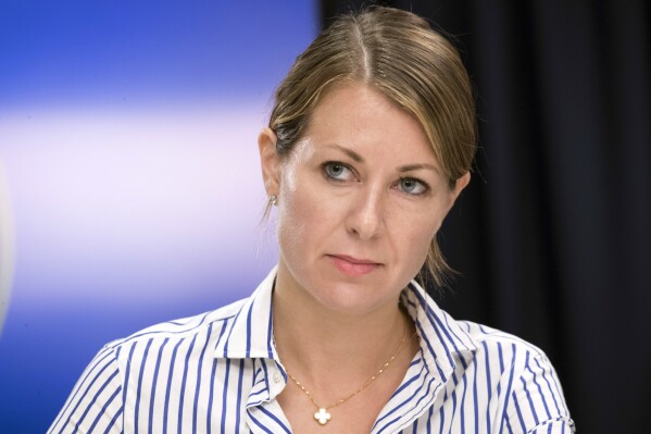 FILE - Secretary to the Governor Melissa DeRosa listens as then-New York Gov. Andrew Cuomo speaks to reporters during a news conference, Sept. 14, 2018, in New York. Cuomo's inner circle began readying a possible campaign in 2022 to reclaim the office he resigned from during a sexual harassment scandal, but he didn't want to subject his daughters to another run, DeRosa, his former top aide, says in a book to be released Tuesday, Oct. 24, 2023. (AP Photo/Mary Altaffer, File)