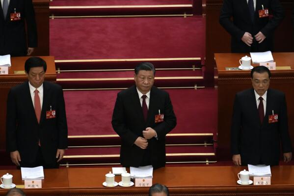 From left, Li Zhanshu, Chinese President Xi Jinping, and Premier Li Keqiang stand during the opening session of China's National People's Congress (NPC) at the Great Hall of the People in Beijing, Sunday, March 5, 2023. (AP Photo/Ng Han Guan)