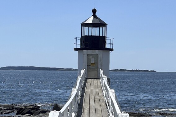 The Marshall Point lighthouse sits on the water's edge with its damaged light removed after a July 27 lightning strike Wednesday, Aug. 2, 2023, in the village of Port Clyde, Maine. (Nat Lyon/Marshall Point Lighthouse and Museum via AP)