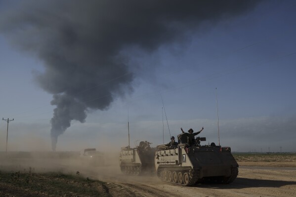 FILE - Israeli soldiers move on armored personnel carriers (APC) near the Israeli-Gaza border as smoke rises to the sky in the Gaza Strip, seen from southern Israel on Jan. 21, 2024. (AP Photo/Leo Correa, File)