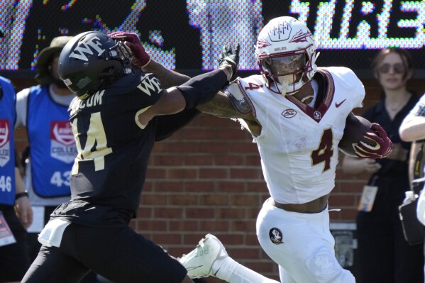 Florida State wide receiver Keon Coleman (4) pushes past Wake Forest defensive back Evan Slocum (14) for a touchdown during the first half of an NCAA college football game in Winston-Salem, N.C., Saturday, Oct. 28, 2023. (AP Photo/Chuck Burton)