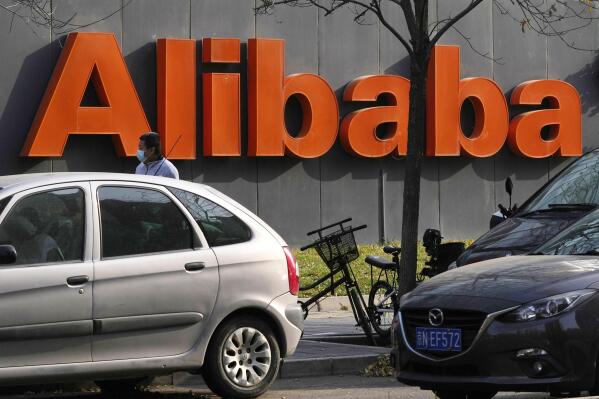 FILE - The Alibaba logo is seen outside a building in Beijing on Nov. 16, 2021. Chinese e-commerce giant Alibaba said in a statement Monday, Dec. 6, 2021, that it is replacing its CFO and restructuring its business as the company weathers a multifaceted crackdown on the industry. (AP Photo/Ng Han Guan, File)