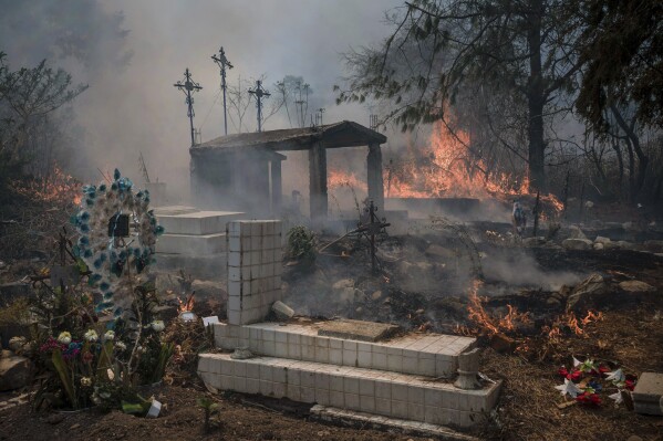 Wildfires burn parts of a cemetery in Nogales, Mexico, Monday, March 25, 2024. Emergency crews are working to contain wildfires burning across parts of the High Mountains area in Veracruz state. (AP Photo/Felix Marquez)