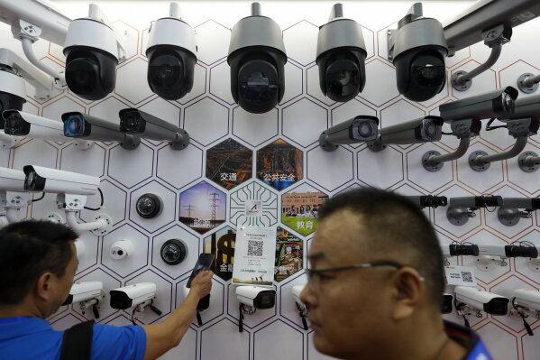 FILE - In this Oct. 29, 2019, file photo visitors look at the surveillance cameras by China's telecoms equipment giant Huawei on display at the China Public Security Expo in Shenzhen, China's Guangdong province. A federal judge in Texas has dismissed Chinese tech giant Huawei's lawsuit challenging a U.S. law that bars the government and its contractors from using Huawei equipment because of security concerns. (AP Photo/Andy Wong, File)
