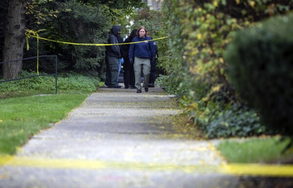 A law enforcement agent walks near the scene near the scene where a Detroit synagogue president, Samantha Woll, was found dead in Detroit on Saturday, Oct. 21, 2023. Woll, a Detroit synagogue president was found slain outside her home with multiple stab wounds Saturday, police said. (David Rodriguez Munoz/Detroit Free Press via AP)