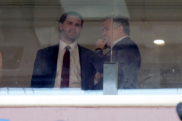 Vice President-elect JD Vance, left, and Senator-elect Dave McCormick, R-Pa., speak at the NCAA college football game between Army and Navy at Northwest Stadium in Landover, Md., Saturday, Dec. 14, 2024. (AP Photo/Stephanie Scarbrough)