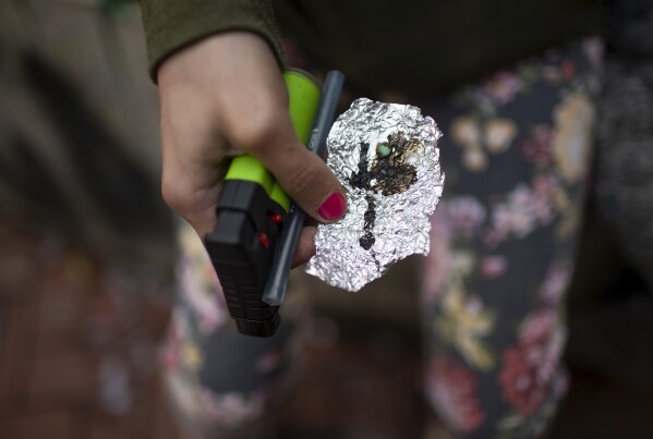 FILE - A person holds drug paraphernalia near the Washington Center building on SW Washington St. in downtown Portland, Ore. on Tuesday, April 4, 2023. The fight against fentanyl is increasingly being waged in schools, jails and on city streets in the Pacific Northwest, where state officials in Oregon and Washington have named it a top issue in upcoming legislative sessions amid a sharp increase in overdose deaths. (Dave Killen/The Oregonian via AP, File)