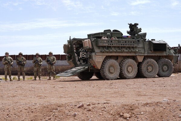 Members of the U.S. Army 212 Infantry 2nd Brigade stand next to an M1126 Stryker vehicle parked at the US-Mexico border, as part of Joint Task Force Southern Border, Thursday, April 3, 2025, in Douglas, Ariz. (AP Photo/Ross D. Franklin)