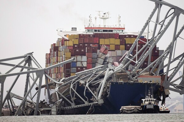 FILE - A cargo ship is stuck under the part of the structure of the Francis Scott Key Bridge after the ship hit the bridge Wednesday, March 27, 2024, in Baltimore, Md. On Thursday, March 28, The Associated Press reported on stories circulating online incorrectly claiming the captain of Dali, the container ship that crashed into Baltimore’s Francis Scott Key Bridge, is Ukrainian. (AP Photo/Steve Helber)