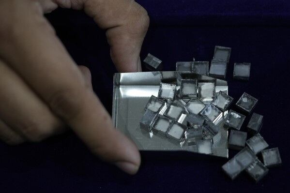 Um homem coleta diamantes brutos cultivados em laboratório na Greenlab Diamonds, em Surat, Índia, segunda-feira, 5 de fevereiro de 2024. Diamantes, sejam cultivados em laboratório ou naturais, são quimicamente idênticos e feitos inteiramente de carbono.  (Foto AP/Ajit Solanki)