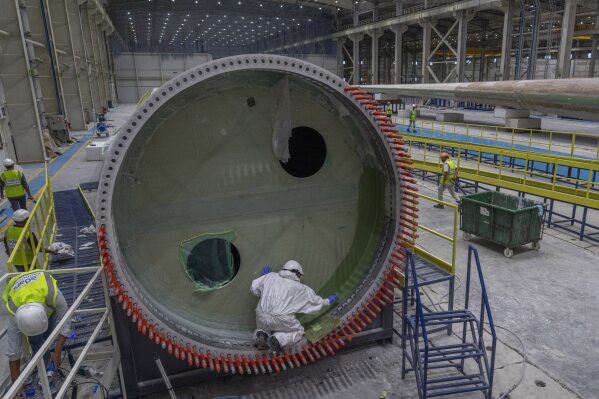 Employees work on a wind turbine blade at the Adani New Industries Limited in the port town of Mundra in Western India's Gujarat state, India, Sept. 20, 2023. (AP Photo/Rafiq Maqbool, File)