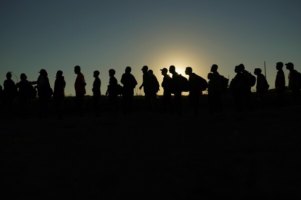 FILE - Migrants who crossed the Rio Grande and entered the U.S. from Mexico are lined up for processing by U.S. Customs and Border Protection, Sept. 23, 2023, in Eagle Pass, Texas. The Biden administration is expected to keep the cap on refugees admitted into the country at 125,000 for the next fiscal year, which starts Sunday. (AP Photo/Eric Gay, File)
