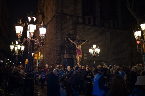 Worshippers carry an image of the Holy Christ of the Blood during a procession asking for rain through the streets of downtown Barcelona, Spain, Saturday, March 9, 2024. A religious procession organised by the Brotherhoods of the Archdiocese of Barcelona marched through the city downtown asking for rain coinciding with just the rainiest day of the year. Spain's northeastern region of Catalonia declared a drought emergency for the area of around 6 million people including the city of Barcelona. (AP Photo/Emilio Morenatti)