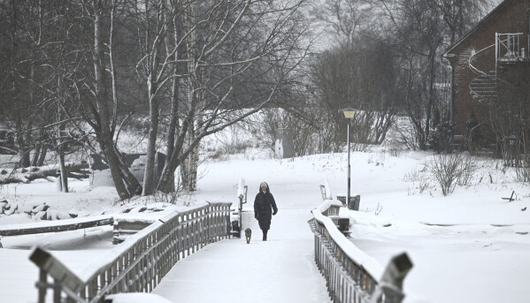2024年1月4日木曜日、フィンランドのヘルシンキで犬の散歩をする女性。北欧地域では2日連続で気温がマイナス40度を下回り、スウェーデンのラップランドでは1月の最低気温が25年ぶりに記録された。  (ヘイキ・サウクマ/Lehticova、AP経由)