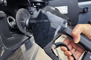 FILE - A customer pumps gas at a gas station in Mundelein, Ill., Feb. 8, 2024. A Nebraska woman is facing theft charges, accusing her of exploiting a gas pump glitch at a Lincoln, Neb. service station. Authorities say the woman found that by double-swiping a rewards card, she could put the pump into demo mode and get free gas. She's accused of costing the station nearly $28,000 in gas over a seven-month period. (AP Photo/Nam Y. Huh, file)