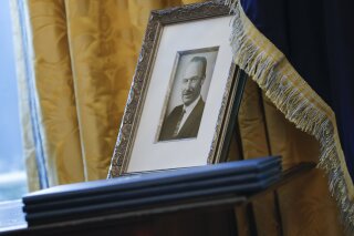 FILE - In this Feb. 9, 2017, file photo, a portrait of President Donald Trump's father Fred Trump, and three un-signed Executive orders are seen in the Oval Office of the White House in Washington. The New York Times is reporting that President Donald Trump received at least $413 million from his father over the decades, much of that through dubious tax dodges, including outright fraud. (AP Photo/Pablo Martinez Monsivais, File)