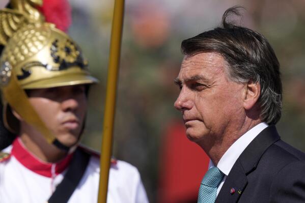 FILE - Brazil's President Jair Bolsonaro arrives for a ceremony marking Army Day at Army headquarters in Brasilia, Brazil, April 19, 2022. Bolsonaro signed a decree on May 19, 2022 that he says will create a national carbon market to reduce greenhouse gas emissions.  (AP Photo/Eraldo Peres, File)
