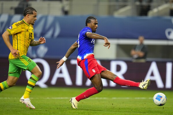 United States' Haji Wright, right, shoots a goal in front of Jamaica's Joel Latibeaudiere during the first overtime half of a CONCACAF Nations League semifinals soccer match, Thursday, March 21, 2024, in Arlington, Texas. (AP Photo/Julio Cortez)