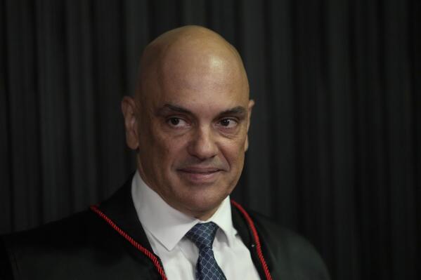 FILE - Judge Alexandre de Moraes stands as he is sworn in as the new head of the Supreme Electoral Tribunal, the government body that oversees elections, ahead of the Oct. 2 elections in Brasilia, Brazil, Aug. 16, 2022. De Moraes has been aggressively pursuing those suspected of undermining Brazil’s democracy, whether it's investigating former President Jair Bolsonaro, arresting protesters on slim evidence or banishing some people from social media after they were accused of spreading conspiracy theories. (AP Photo/Eraldo Peres, File)