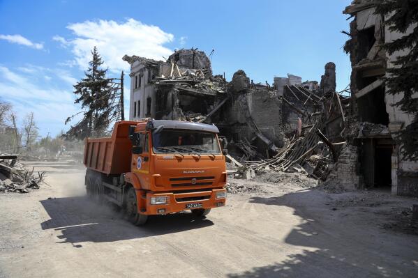 FILE - A truck drives past the Donetsk Academic Regional Drama Theatre in Mariupol, Ukraine, following the March 16, 2022, bombing when the theater was used as a shelter, in an area now controlled by Russian forces in Ukraine, April 27, 2022. (AP Photo/Alexei Alexandrov, File)