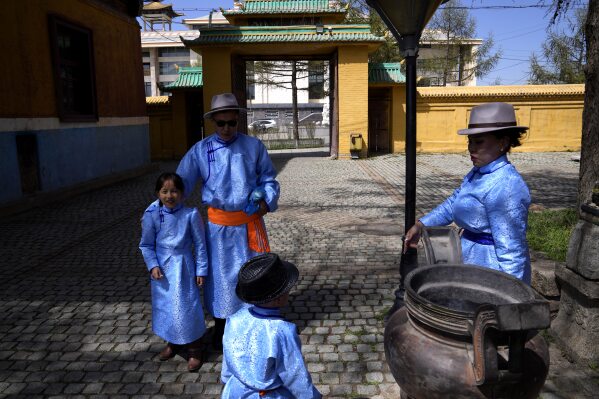 A family wearing traditional clothing visits famous Gandan Buddhist monastery on the first day of summer, in Ulaanbaatar, the capital of Mongolia, Monday, May 22, 2023. (AP Photo/Manish Swarup)