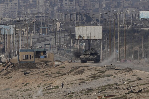 2024年6月9日，星期日，一名巴勒斯坦人在加沙地带中部逃离以色列坦克。（美联社照片/阿卜杜勒·卡里姆·哈纳）