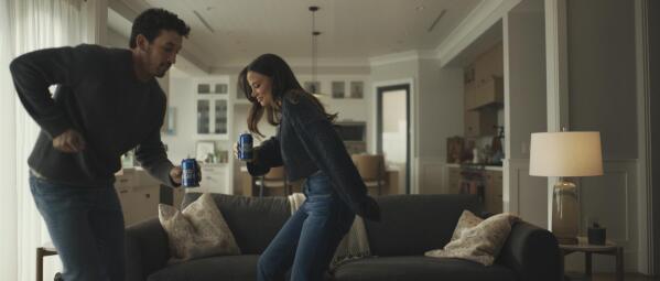 This photo provided by Bud Light shows actor Miles Teller and his wife Keleigh Sperry in a scene from Bud Light 2023 Super Bowl NFL football spot. A bevy of booze brands will be in the Super Bowl ad lineup this year, now that Anheuser-Busch has ended its exclusive advertising sponsorship after more than 30 years. Anheuser-Busch, parent of the Budweiser, Michelob Ultra and Busch beer brands, said in June it would end its exclusivity deal, which it first struck in 1989, and focus on other marketing efforts. (Bud Light via AP)