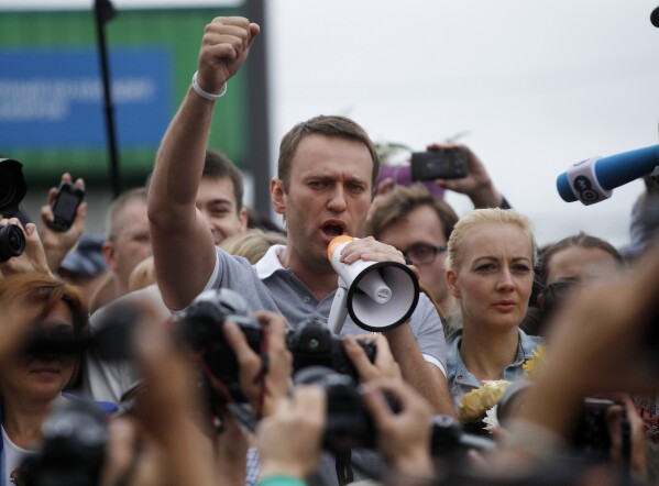 Russian opposition leader Alexei Navalny, center, addresses supporters and journalists after arriving from Kirov at a railway station in Moscow, Russia, Saturday, July 20, 2013. (AP Photo/ Dmitry Lovetsky, File)