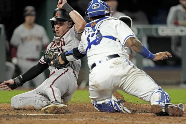 Arizona Diamondbacks' Jake McCarthy is tagged out by Kansas City Royals catcher Salvador Perez as he tried to score on a fielders choice hit into by Alek Thomas during the ninth inning of a baseball game Tuesday, Aug. 23, 2022, in Kansas City, Mo. The Diamondbacks won 7-3. (AP Photo/Charlie Riedel)