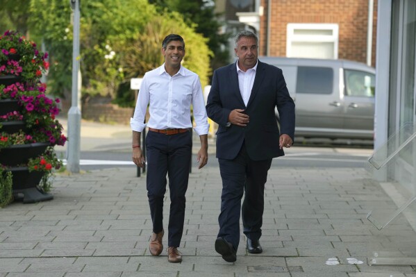Britain's Prime Minister Rishi Sunak, left and newly elected Conservative MP Steve Tuckwell arrive at the Rumbling Tum cafe in Uxbridge, following the party's success in the Uxbridge and South Ruislip by-election, West London, Friday July 21, 2023. Britain's governing Conservative Party suffered two thumping defeats Friday in a trio of special elections but avoided a drubbing after holding onto former premier Boris Johnson's seat in suburban London. (Carl Court/Pool Photo via AP)