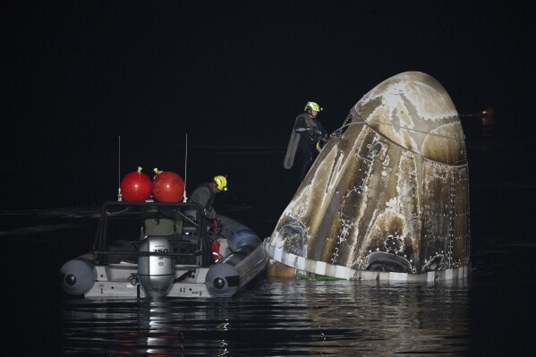 Support teams work around the SpaceX Dragon Endurance spacecraft shortly after it landed with NASA astronaut Jasmin Moghbeli, European Space Agency astronaut Andreas Mogensen, Japan Aerospace Exploration Agency astronaut Satoshi Furukawa, and Russia cosmonaut Konstantin Borisov aboard in the Gulf of Mexico off the coast of Pensacola, Fla., Tuesday, March 12, 2024. (Joel Kowsky/NASA via AP)