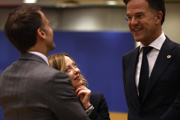 Italy's Prime Minister Giorgia Meloni, center, looks up at Netherland's Prime Minister Mark Rutte and French President Emmanuel Macron during a round table meeting at an EU summit in Brussels, Wednesday, April 17, 2024. European leaders' discussions at a summit in Brussels were set to focus on the bloc's competitiveness in the face of increased competition from the United States and China. Tensions in the Middle East and the ongoing war between Russia and Ukraine decided otherwise and the 27 leaders will dedicate Wednesday evening talks to foreign affairs. (AP Photo/Omar Havana)