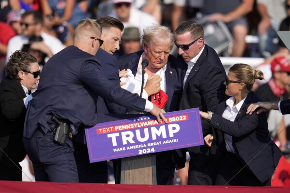 Republican presidential candidate former President Donald Trump is helped off the stage at a campaign event in Butler, Pa., Saturday, July 13, 2024. (AP Photo/Gene J. Puskar)