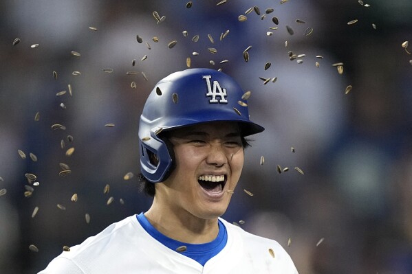 Los Angeles Dodgers designated hitter Shohei Ohtani has sunflower seeds tossed at him by Teoscar Hernandez after hitting a two-run home run during the third inning of a baseball game Friday, May 17, 2024, in Los Angeles. (AP Photo/Mark J. Terrill)