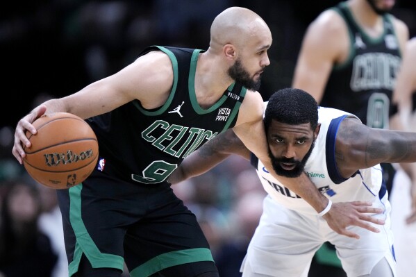 Boston Celtics guard Derrick White (9) holds back Dallas Mavericks guard Kyrie Irving while looking to pass during the second half of Game 2 of the NBA Finals basketball series, Sunday, June 9, 2024, in Boston. (AP Photo/Steven Senne)