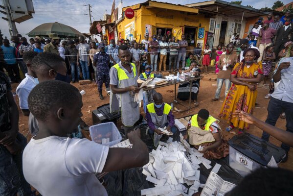 Election officials count the ballots after polls closed in Kampala, Uganda, Thursday, Jan. 14, 2021.Ugandans voted in a presidential election tainted by widespread violence that some fear could escalate as security forces try to stop supporters of leading opposition challenger Bobi Wine from monitoring polling stations. (AP Photo/Jerome Delay)