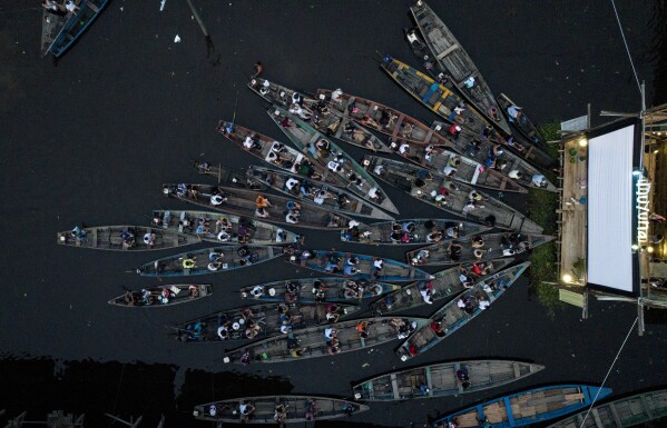 Residnets watch a film from boats during the Muyuna Floating Film Festival in the Belen neighborhood of Iquitos, Peru, Sunday, May 26, 2024. (AP Photo/Rodrigo Abd)