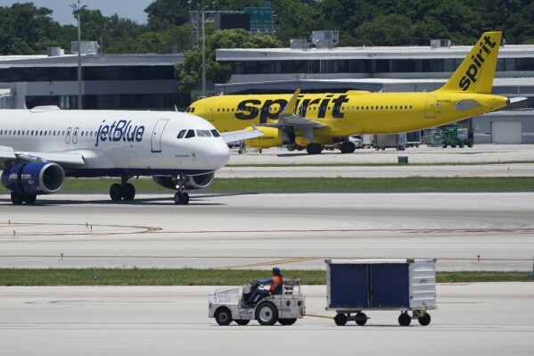 FILE - A JetBlue Airways Airbus A320, left, passes a Spirit Airlines Airbus A320 as it taxis on the runway, July 7, 2022, at the Fort Lauderdale-Hollywood International Airport in Fort Lauderdale, Fla. What's next for Spirit Airlines, now that it won't be merging with JetBlue? Some Wall Street analysts are starting to raise the possibility of bankruptcy. Spirit Airlines stock was falling again on Wednesday, Jan 17, 2024, a day after a federal judge blocked JetBlue's proposed $3.8 billion purchase of Spirit. (AP Photo/Wilfredo Lee, File)