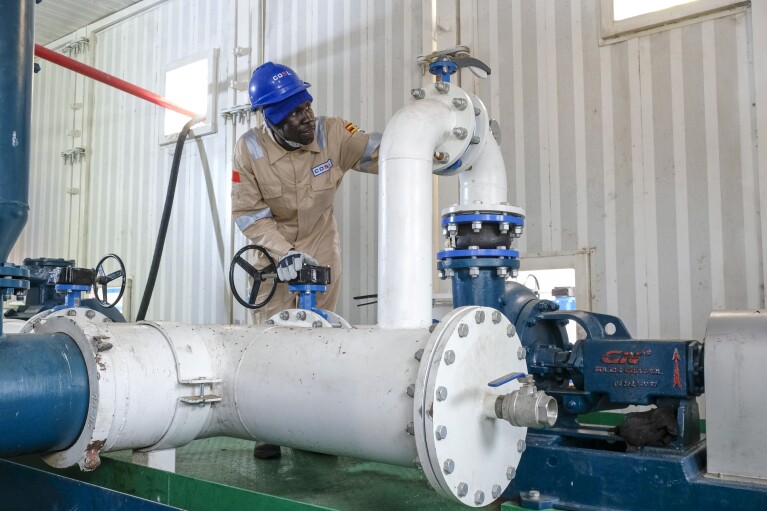 A Ugandan worker from China Oilfield Services Limited (COSL), a contractor for China National Offshore Oil Corporation (CNOOC), inspects pipes on the drilling rig at the Kingfisher oil field on the shores of Lake Albert in the Kikuube district of western Uganda, Jan. 24, 2023. (AP Photo/Hajarah Nalwadda)