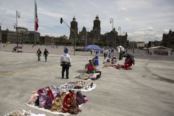 Artisans offer their crafts for sale demanding economic help from the government after their livelihood was severely affected by the new coronavirus lockdown, in Mexico City's main square, the Zocalo, Tuesday, July 28, 2020. With the country facing a deep economic recession, Mexican President Andres Manuel Lopez Obrador has pushed to reopen the economy quickly even as COVID-19 infections and deaths continue to rise. (AP Photo/Fernando Llano)