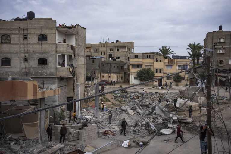 Palestinians inspect the ruins of the Hassouna family home, which was bombed by an Israeli airstrike during an operation to rescue two hostages in Rafah, southern Gaza Strip, Tuesday, February 13, 2024. Ibrahim Hassouna, who was absent at the time of the airstrike, says his entire family was killed, including This includes his parents, two brothers, his sister-in-law, and three nieces and nephews.  (AP Photo/Fathima Shabir)