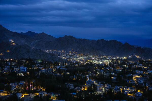 Lights shine in Leh in the cold desert region of Ladakh, India, Tuesday, Sept. 20, 2022. Konchok Dorjey gave up his pastoral life in search of a better future for his family. He sold off his animals and migrated to an urban settlement in the outskirts of Leh. (AP Photo/Mukhtar Khan)