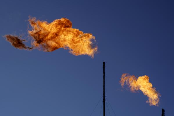 FILE - Flares burn off methane and other hydrocarbons at an oil and gas facility in Lenorah, Texas, Oct. 15, 2021. The U.N. Environment Programme said Friday, Nov. 11, that the new Methane Alert and Response System — MARS for short — is intended to help companies act on major emissions sources but also provide data in a transparent and independent way. (AP Photo/David Goldman, File)