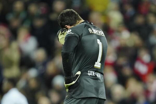 Liverpool's goalkeeper Alisson gestures after Real Madrid's Vinicius Junior scores his side's second goal during the Champions League, round of 16, first leg soccer match between Liverpool and Real Madrid at the Anfield stadium in Liverpool, England, Tuesday, Feb. 21, 2023. (AP Photo/Jon Super)