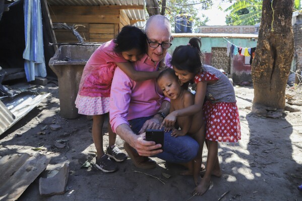 Pastor Kenton Moody spends time with members of the Mendoza Velasquez family at the house where they live under the care of their grandmother because their parents were detained during the government's crackdown on its war against drugs, in Santa Ana, (AP Photo/Salvador Melendez)