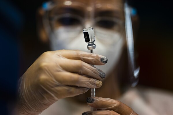 FILE - A nurse prepares a dose of the Pfizer COVID-19 vaccine at the Tomas Dones Coliseum, in Fajardo, Puerto Rico, Jan. 8, 2022. A debate over public health and personal rights intensified on Wednesday, Feb. 14, 2024, as Puerto Rican legislators clashed with medical experts on the use of masks and vaccines. (AP Photo/Carlos Giusti, File)