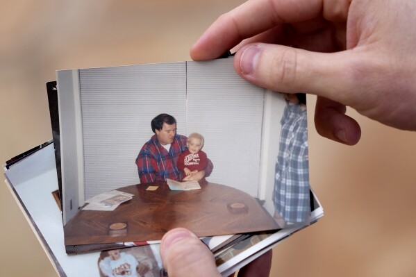 Austin Allen shows a photo of himself with his deceased father, Ted Allen, during an interview in Oklahoma City on March 12, 2025. Austin was 4 years old when his father died in the bombing of the Alfred P. Murrah Federal Building. (AP Photo/LM Otero)