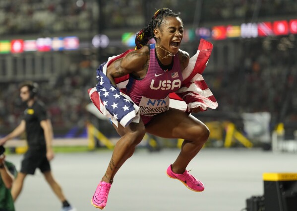 Sha'Carri Richardson, of the United States, shouts out as she celebrates with her gold medal for winning the women's 100 meters during the World Athletics Championships in Budapest, Hungary, Monday, Aug. 21, 2023. (AP Photo/Ashley Landis)