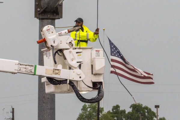 A Pearland city worker attempts to repair a broken power line following a severe thunderstorm that passed through the area Tuesday afternoon May, 28, 2024, in Pearland, Texas. (Kirk Sides/Houston Chronicle via AP)